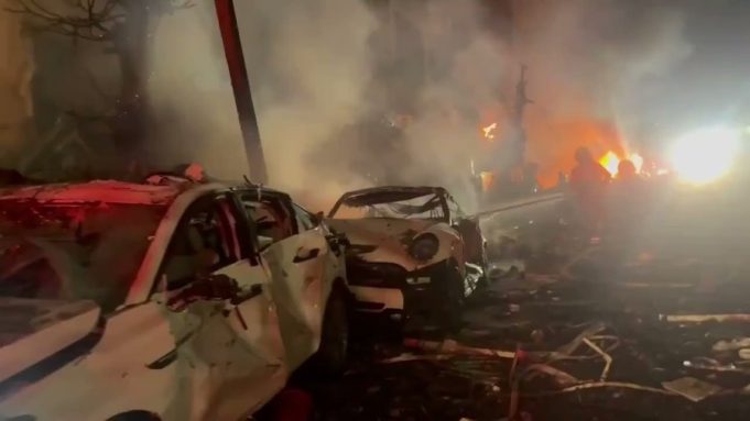 Footage shows the immediate aftermath of an Iranian ballistic missile impact in central Israel, with emergency responders securing the area and assessing damage.